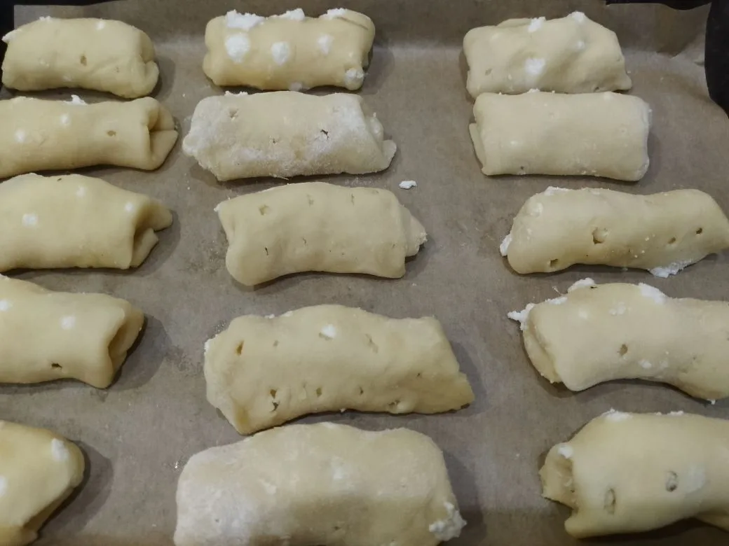 Песочное и рассыпчатое печенье, с начинкой из творога и изюма: Противень застилаем пергаментом и укладываем печенье.