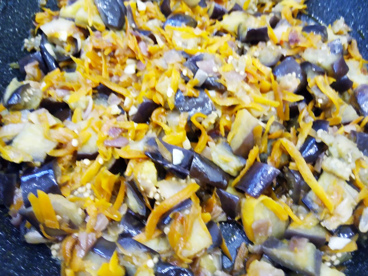 Баклажаны с луком и морковью, тушеные на сковороде: Закрываем сковороду крышкой и тушим до размягчения баклажан. В конце тушения добавляем чеснок, перемешиваем.