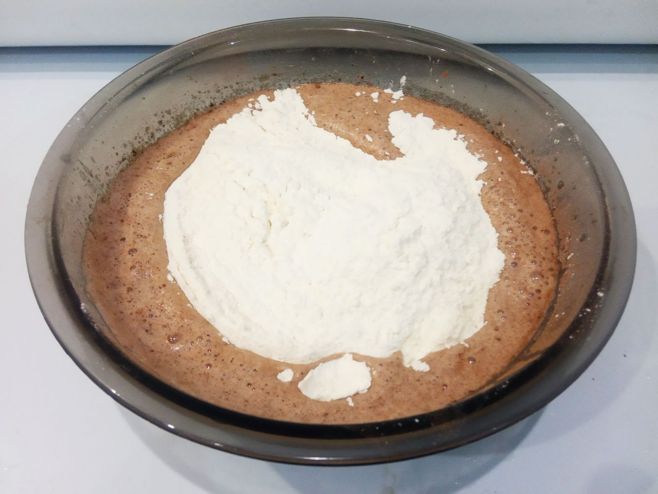 Шоколадный пирог на молоке с яблоками, вкусный и аппетитный: Муку просеиваем через мелкое сито, добавляем в тесто, размешиваем.