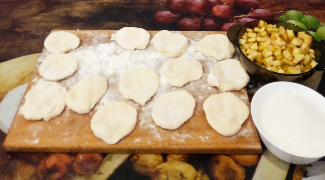 Вкусные сочные жареные пирожки на кефире с яблоками: Каждую часть раскатываем небольшими лепешками.