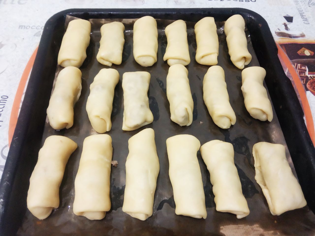 Простой рецепт пирожков из теста на растительном масле, с мясной начинкой: Противень застилаем пергаментом и укладываем пирожки.