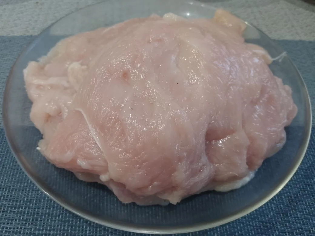 Куриное филе запеченное в беконе, с начинкой из твердого сыра: Разрезаем филе на полоски, накрываем пищевой пленкой и отбиваем.