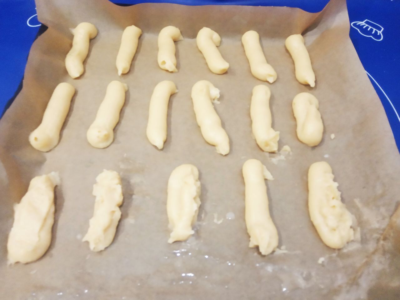 Заварные пирожные с масляным кремом, вкусные и аппетитные: Противень накрываем пергаментом и с помощью кондитерского мешка заварное тесто выпускаем в виде палочек на