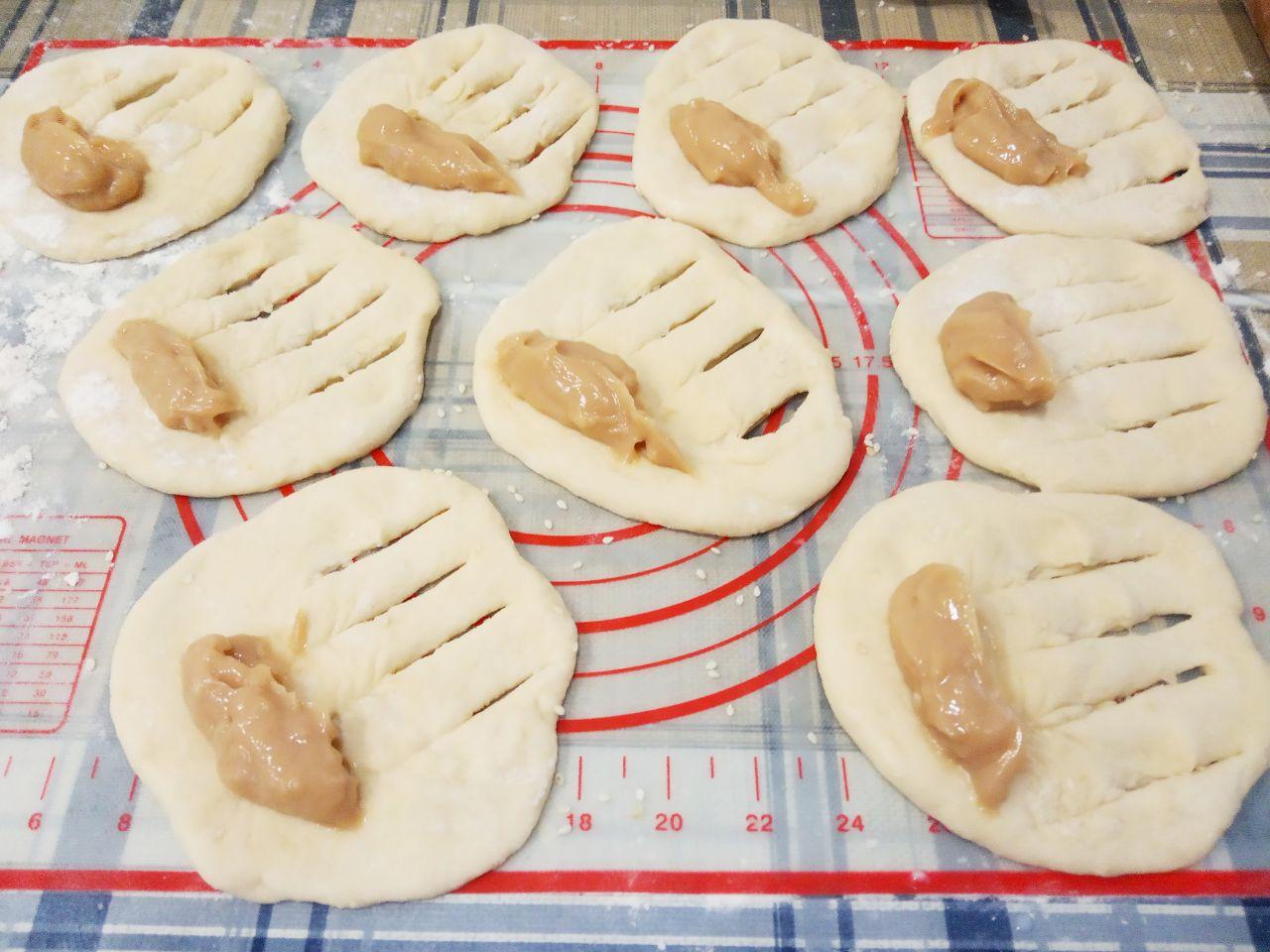 Жареные пончики без яиц с начинкой и с кунжутом: С другой стороны распределяем начинку не до края.
