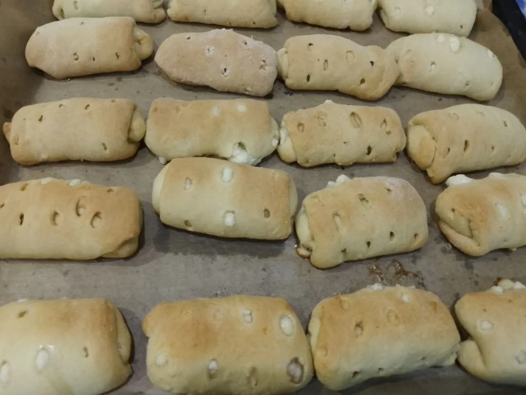 Песочное и рассыпчатое печенье, с начинкой из творога и изюма: Испеченное печенье достаем из духовки и посыпаем сахарной пудрой.