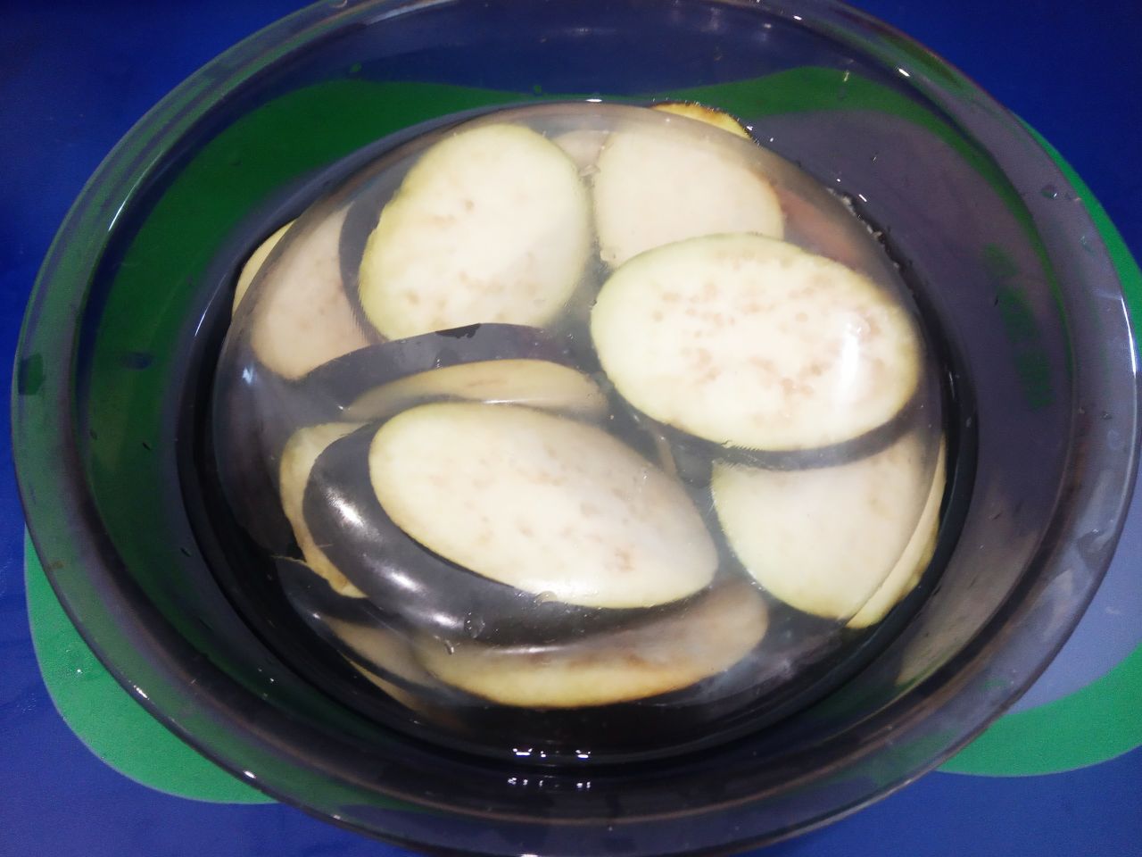 Баклажаны с помидорами и сыром, запеченные в духовке: Баклажаны промываем водой, отрезаем плодоножки и разрезаем на кружочки, я разрезаю на кружочки толщиной около