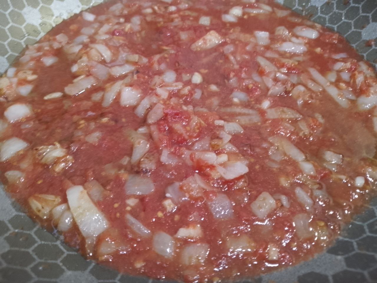 Запеканка зити с мясными шариками, сыром и протертыми помидорами: Добавляем протертые помидоры и тушим несколько минут. Соус солим и перчим по вкусу.