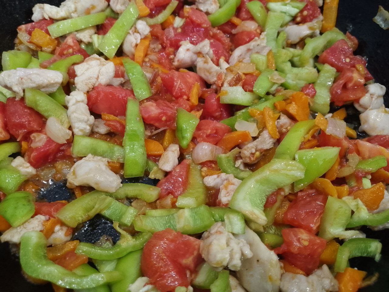 Тушеная спаржевая фасоль с овощами и куриным мясом: Добавляем измельченные помидоры, перец и обжариваем около 5 минут.