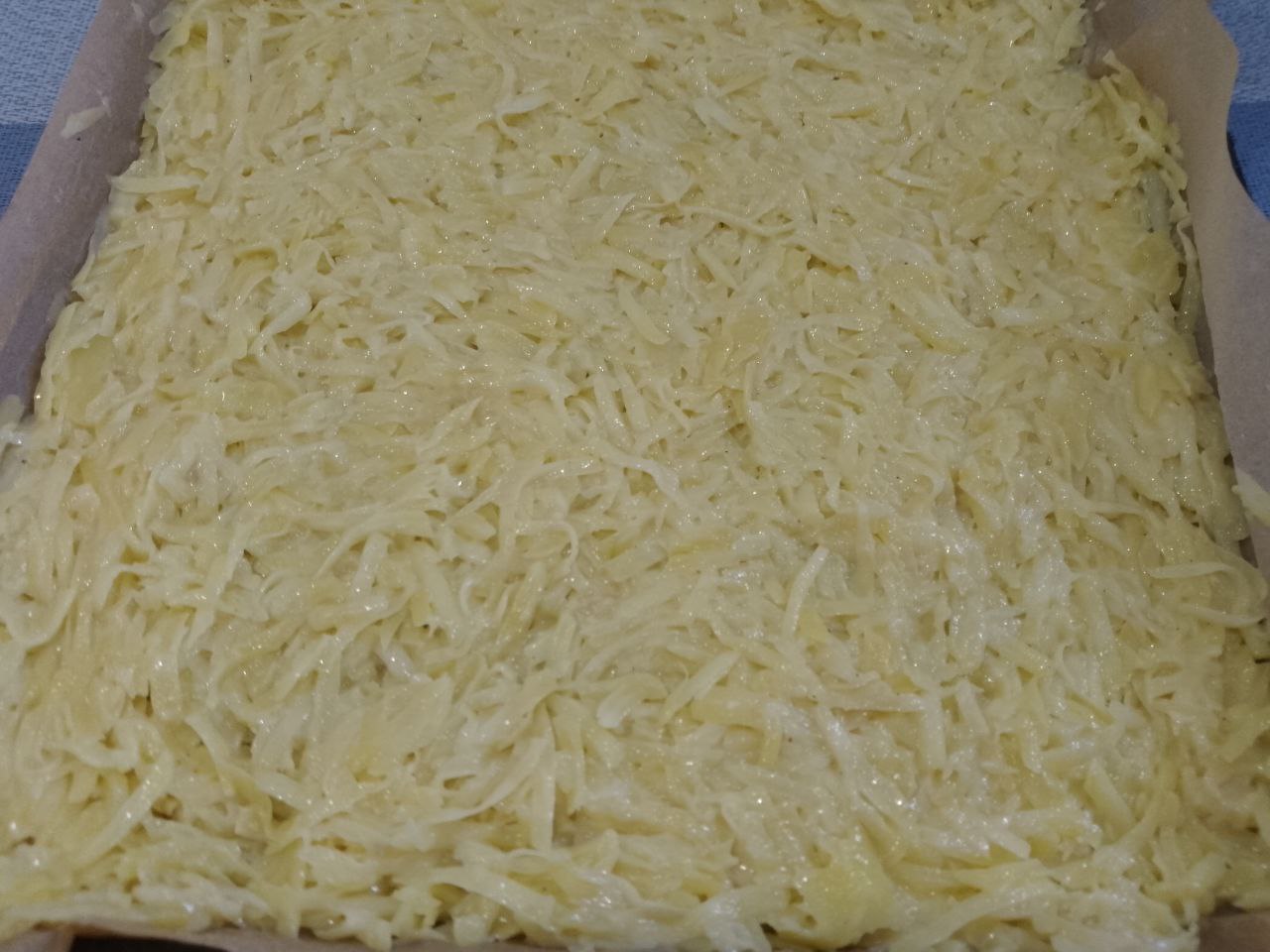 Рулет из тертого картофеля с мясной начинкой, запеченный в духовке: Равномерно распределяем картофель по пергаменту и ставим в разогретую духовку на 20 минут.