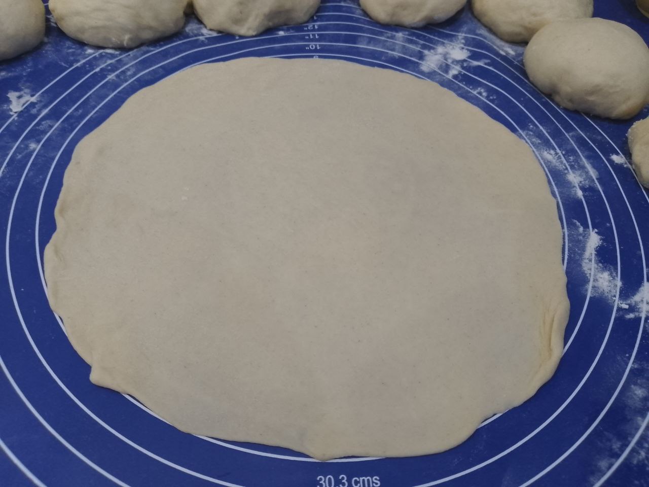 Булочки из слоеного дрожжевого теста с корицей и изюмом: Раскатываем колобок формой тонкого круга толщиной до 2 мм.