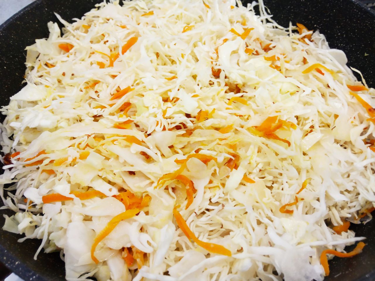 Капустные биточки с фаршем и соусом в духовке: Кладем в сковороду к обжаренным овощам капусту, солим и перчим по вкусу. Овощи перемешиваем и обжариваем