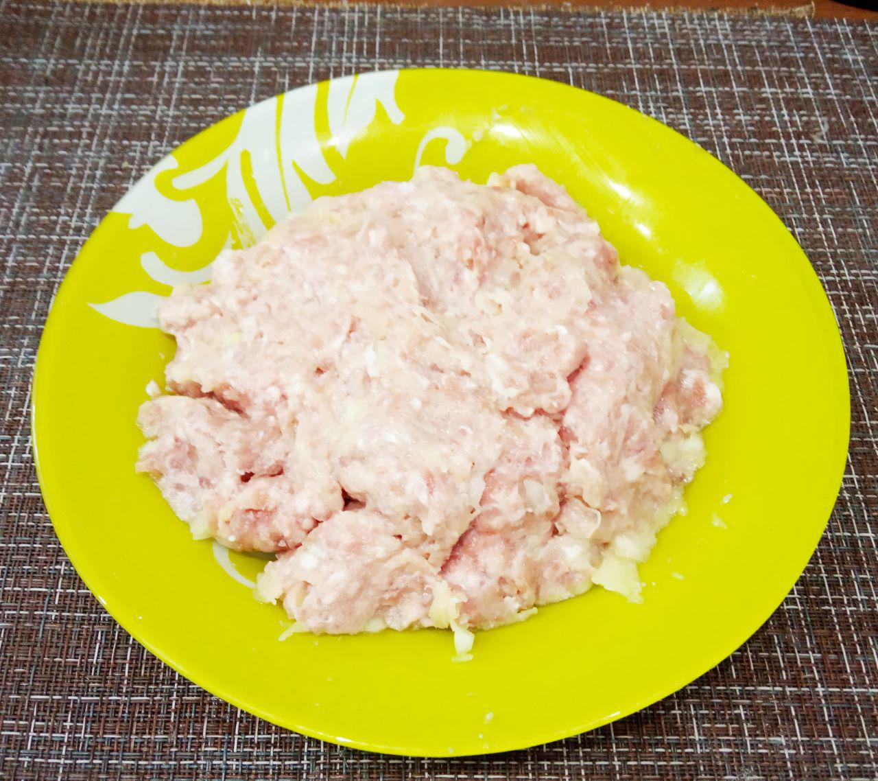Тушеный картофель со свиным фаршем: Соединяем фарш и пропущенные через мясорубку лук с картофелем, солим и перчим по вкусу. Массу тщательно