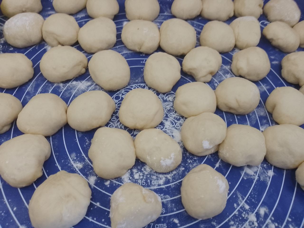 Рогалики из сдобного дрожжевого теста, с начинкой из вареного сгущенного молока: Когда тесто увеличится в объеме, разделяем на небольшие шарики. Накрываем пленкой на 10-15 минут.