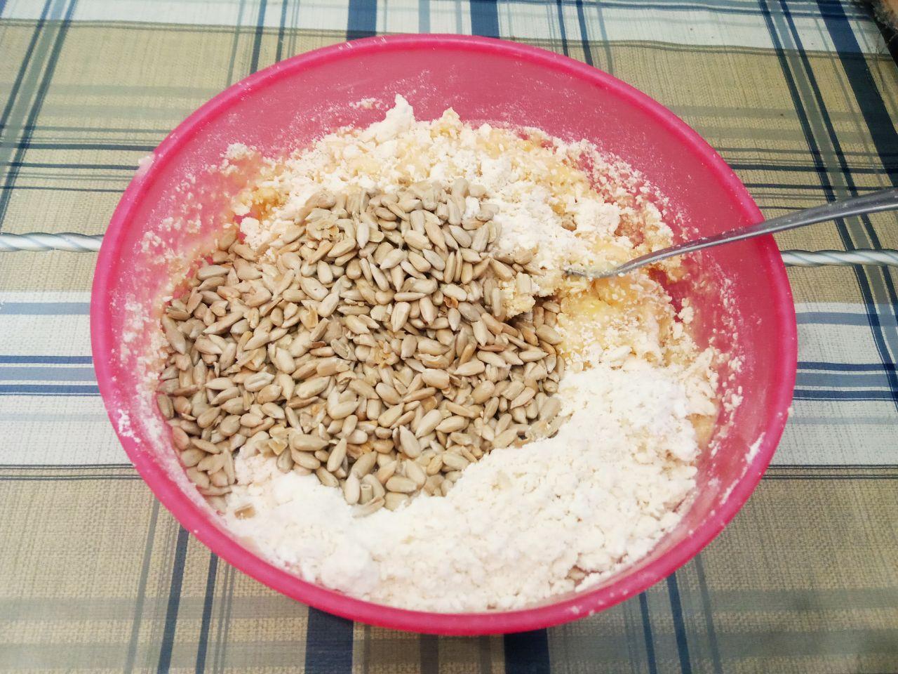 Рассыпчатое печенье с ядрами семечек подсолнечника: Смесь выкладываем в мучную крошку, кладем ядра семян подсолнечника, размешиваем сначала лопаткой, затем
