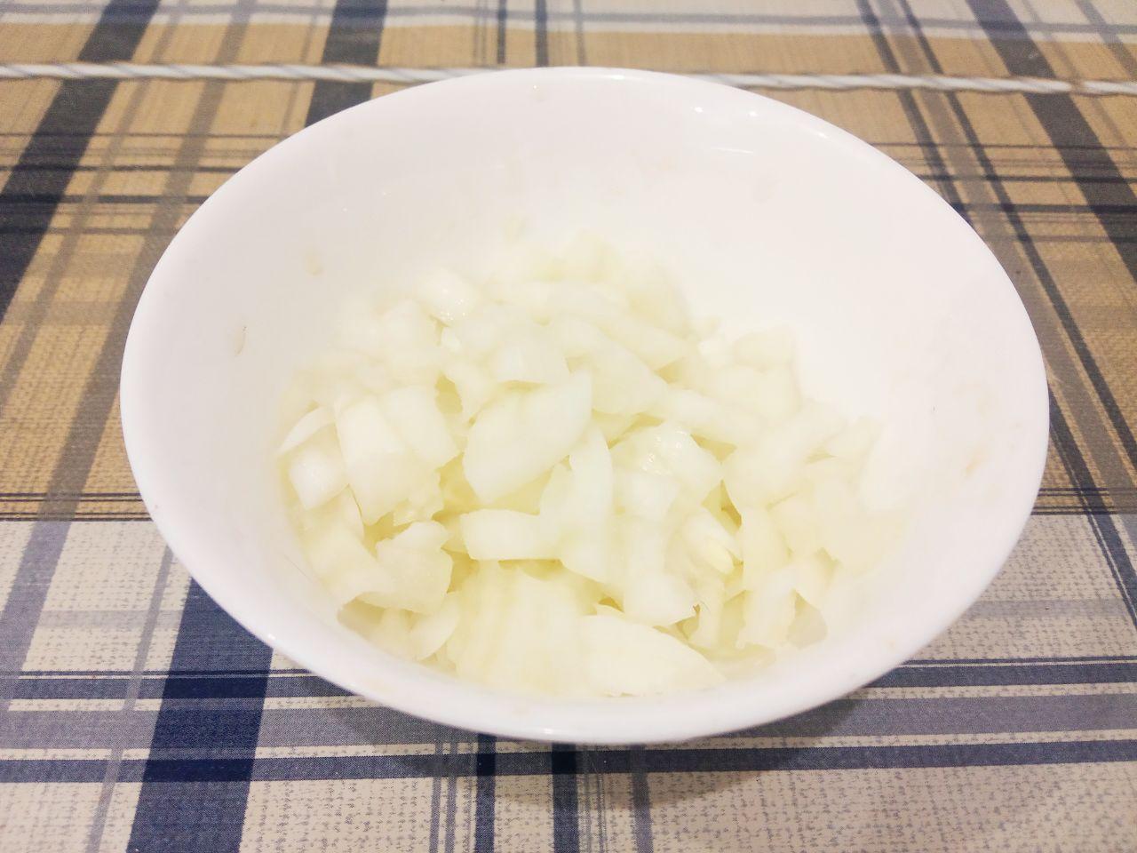 Простой рецепт рассольника с рисом и солеными огурцами: Лук очищаем, промываем и измельчаем.