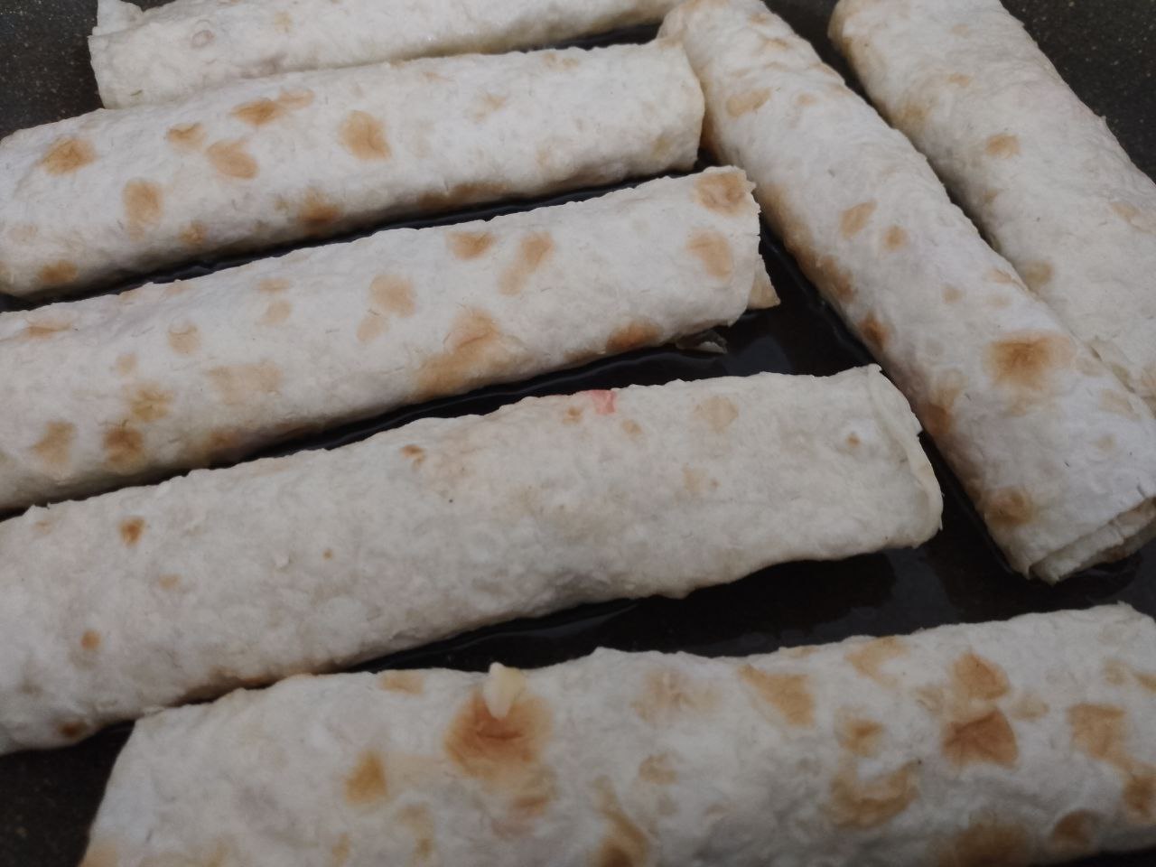 Лаваш с начинкой из куриного мяса, сыра и помидоров: Разогреваем сковороду с растительным маслом и обжариваем рулетики с двух сторон.