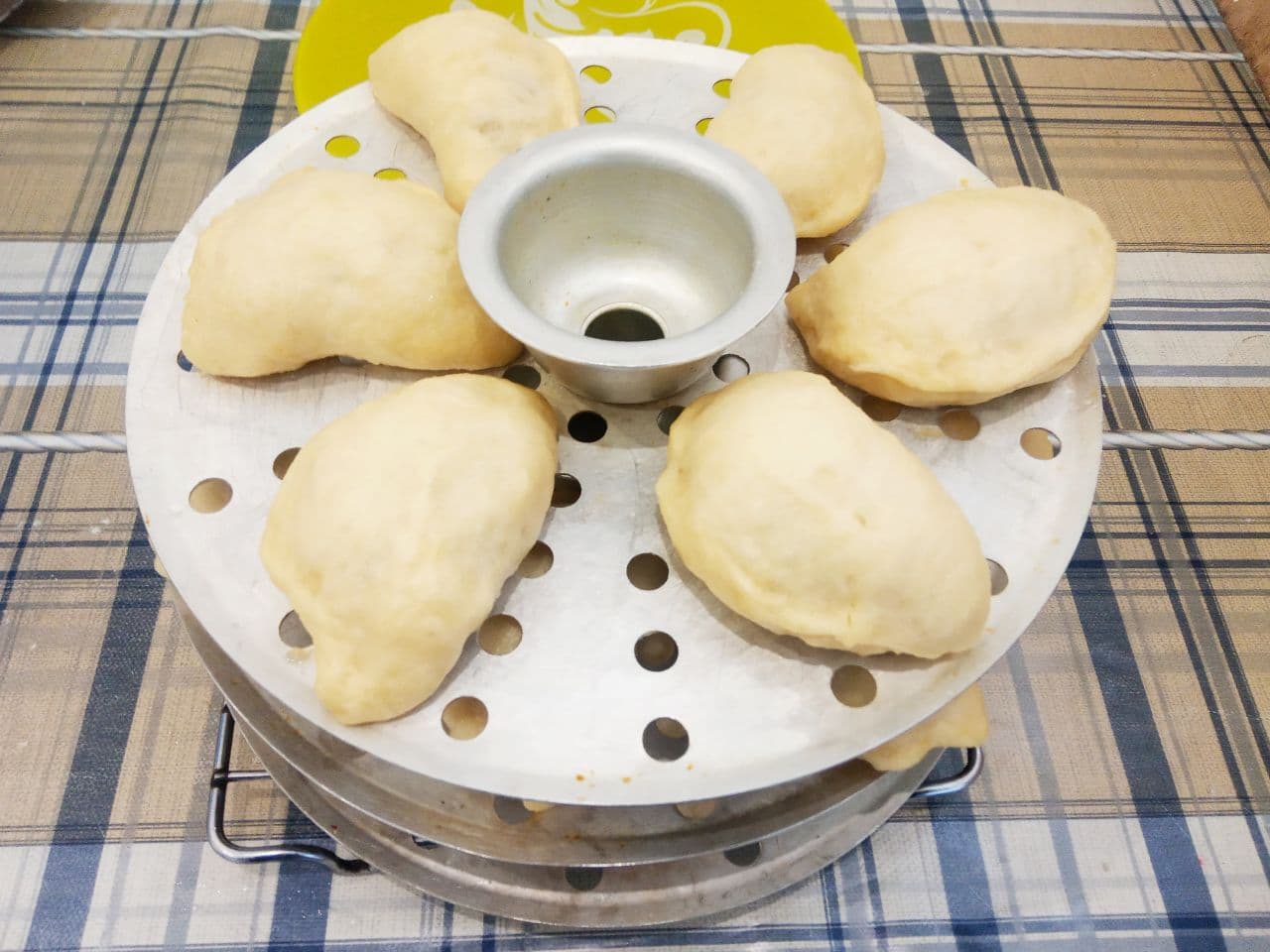 Воздушные вареники с жареной квашеной капустой приготовленные на пару: Когда вода закипит и образуется пар, помещаю решетки с варениками в мантоварку. Накрываю крышкой и варю около