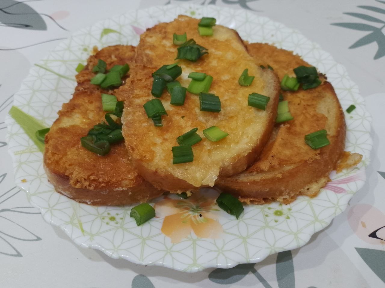 Бутерброды с яйцами и сыром, жареные на сковороде: Готовые ломтики выкладываем на тарелку и посыпаем зеленым луком.