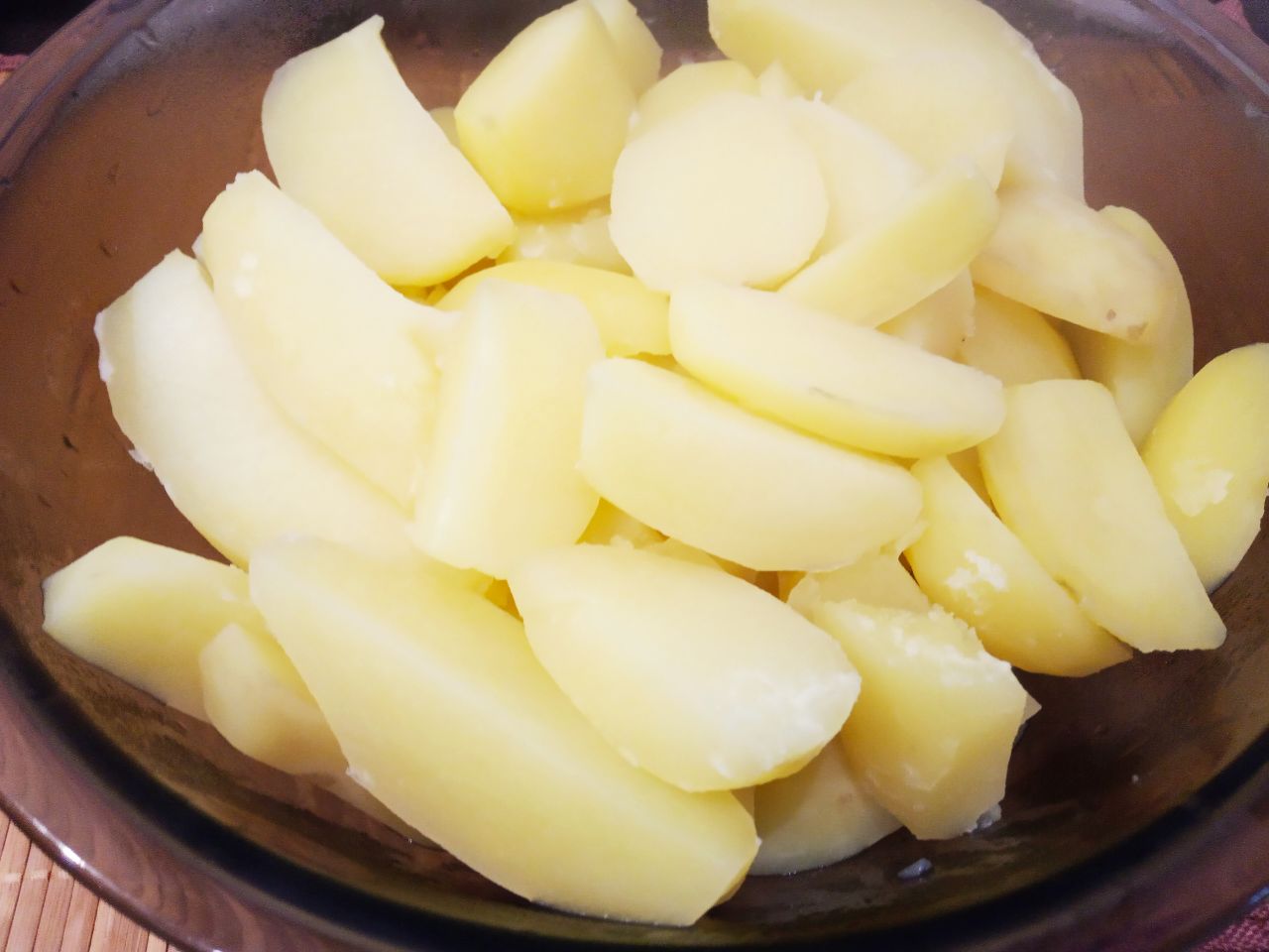 Запеченный молодой картофель в сметане и сыре: Складываем картофель в миску, добавляем перец молотый, сухой чеснок и сметану. Картофель перемешиваем