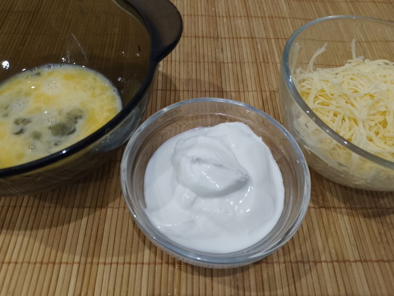 Драники с сыром, яйцом и сметаной: В миску разбиваем яйцо, добавляем тертый сыр и сметану, размешиваем.