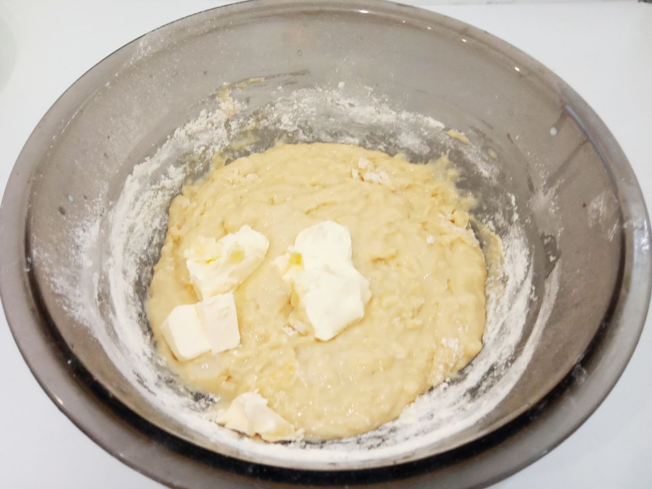 Булочки с изюмом, воздушные и мягкие: Кладем кусочками размягченное сливочное масло, размешиваем.