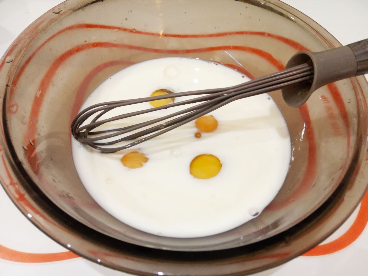 Мясной рулет с сыром в кляре, жареный на сковороде: Добавляем в яичную смесь молоко и взбиваем.