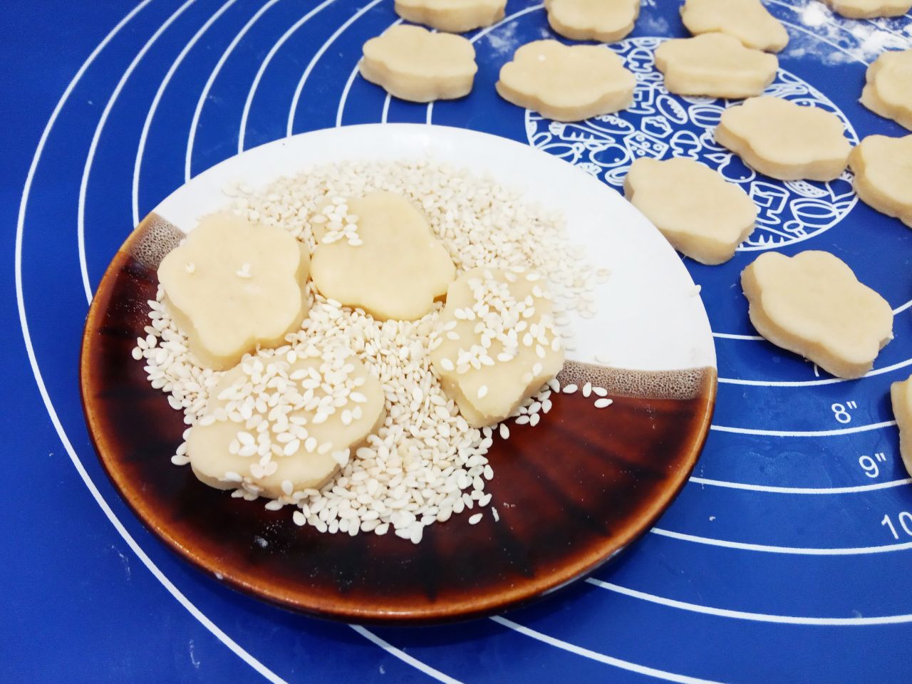 Домашнее песочное и рассыпчатое печенье, с кунжутом: Кунжут насыпаем в тарелочку и окунаем печенье одной стороной в кунжут.