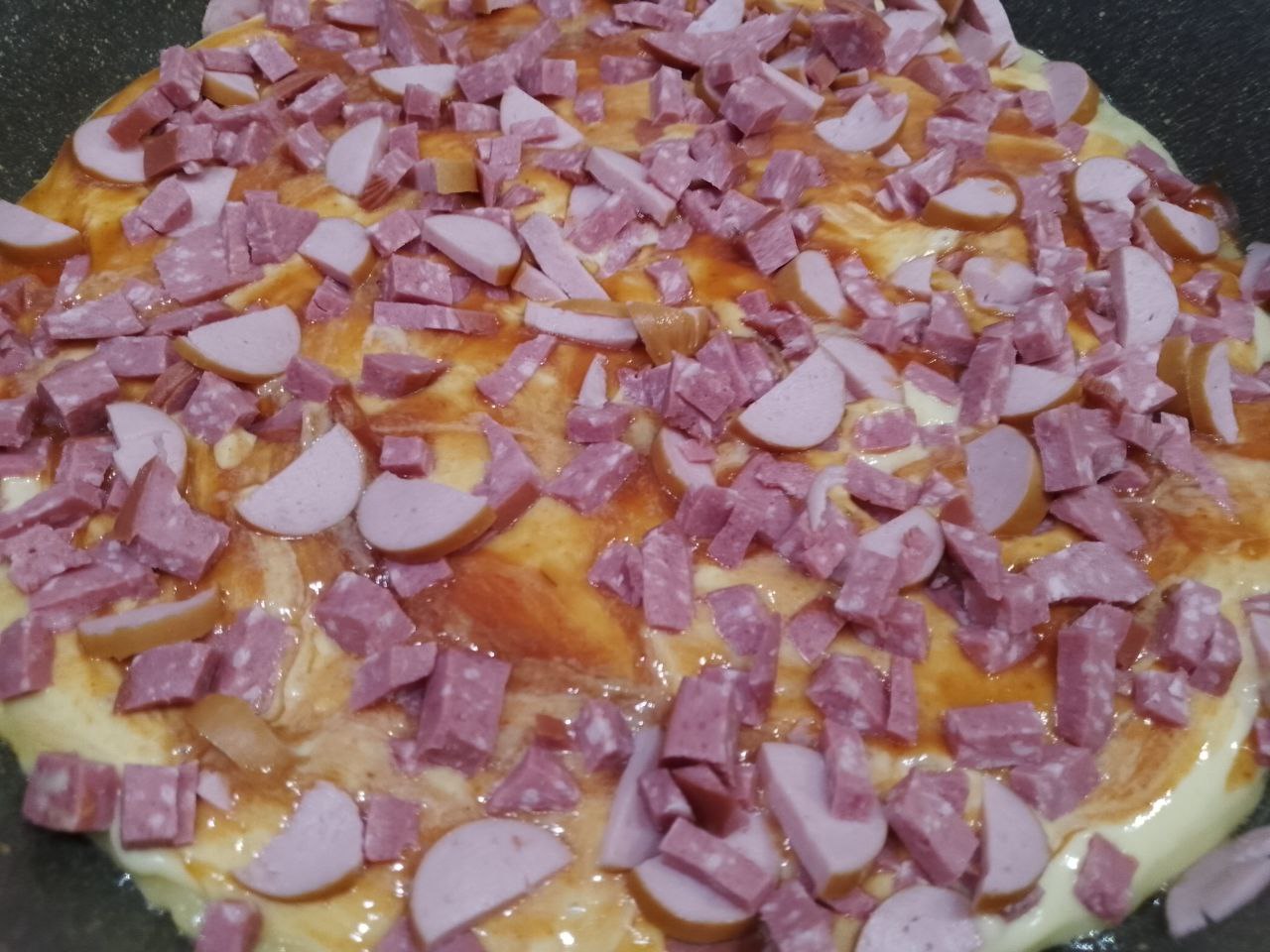 Пицца на сковороде, просто, быстро и вкусно: Выкладываем равномерно измельченную колбасу, сверху смазываем майонезом по вкусу.