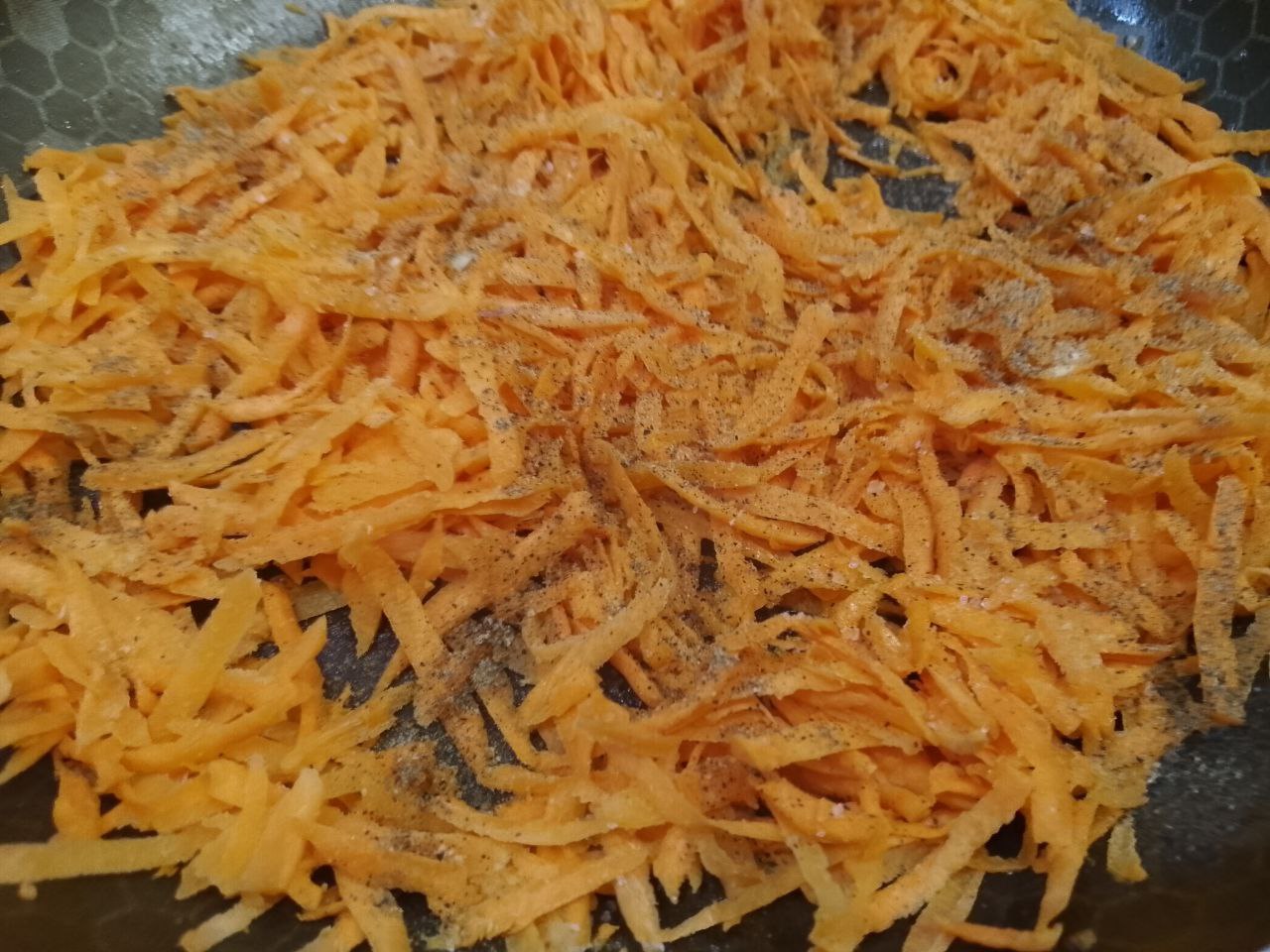 Салат из рыбы, моркови и лука: Выкладываем морковь на разогретую сковороду с растительным маслом, посыпаем специями и обжариваем до мягкости.
