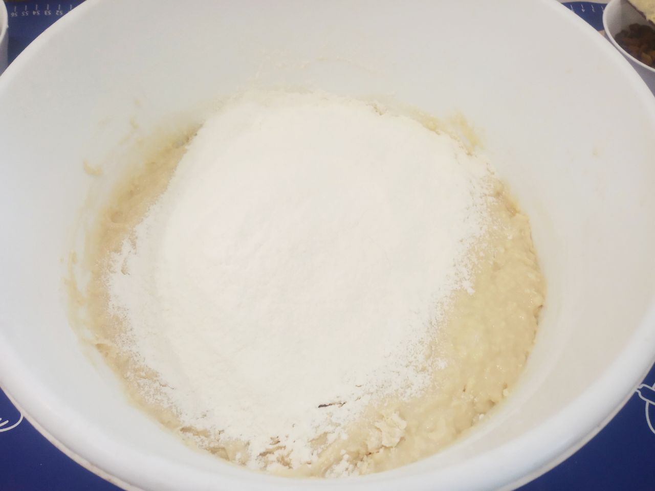 Булочки с начинкой из жареных яблок, изюма и корицы: В размешанное тесто кладем кусочки размягченного сливочного масла, перемешиваем и добавляем оставшуюся муку.
