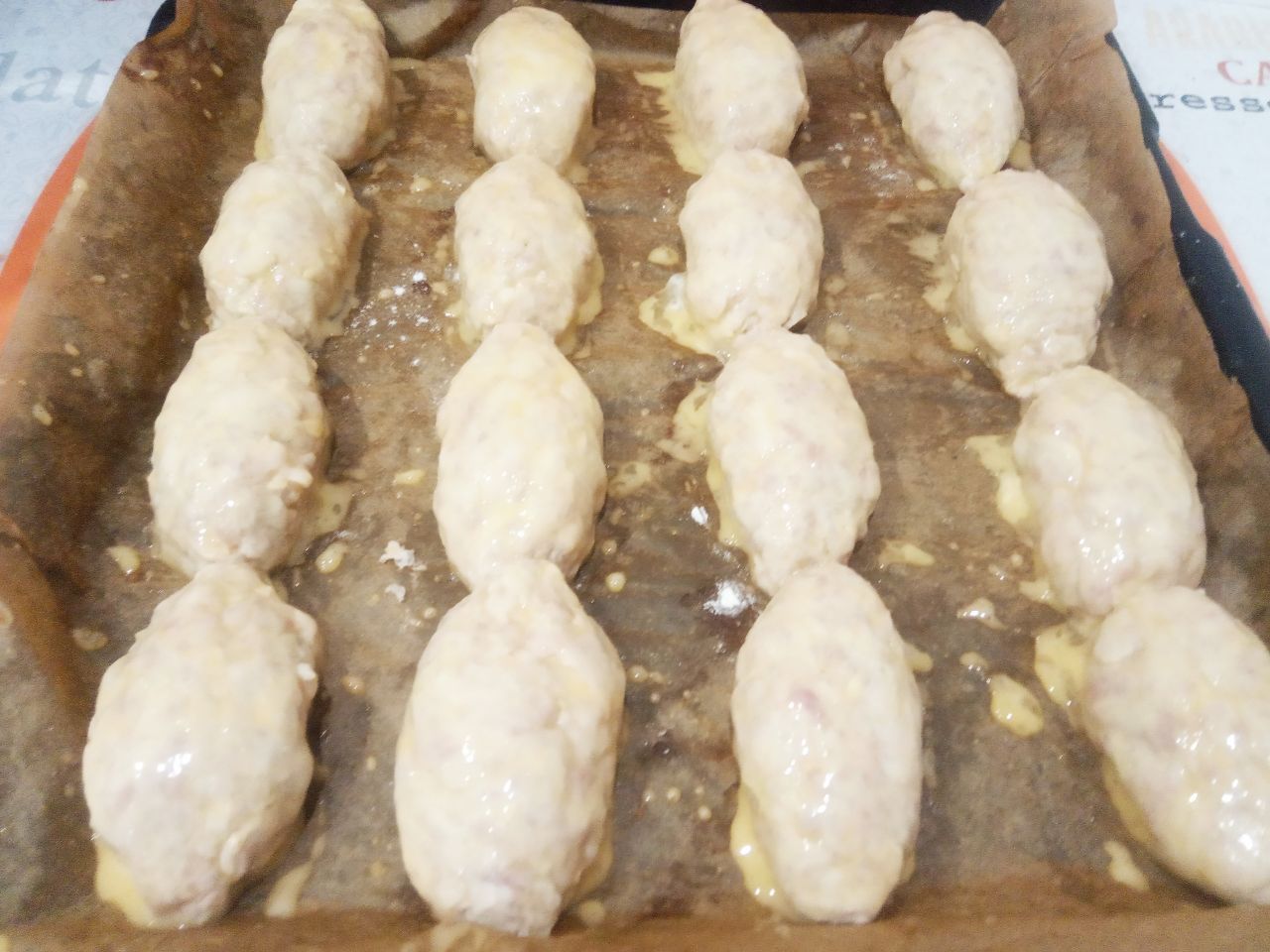 Мясные котлеты, запеченные в духовке, нежные и сочные: Взбиваем яйцо и кисточкой смазываем котлеты.