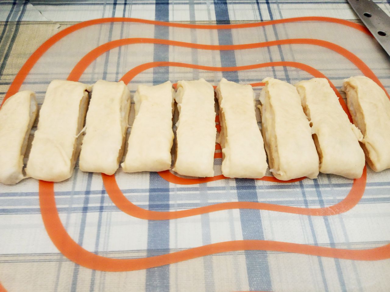 Воздушные и нежные булочки с заварным кремом и изюмом: Полоску теста слегка раскатываем и разрезаем на полоски шириной до 2 см.