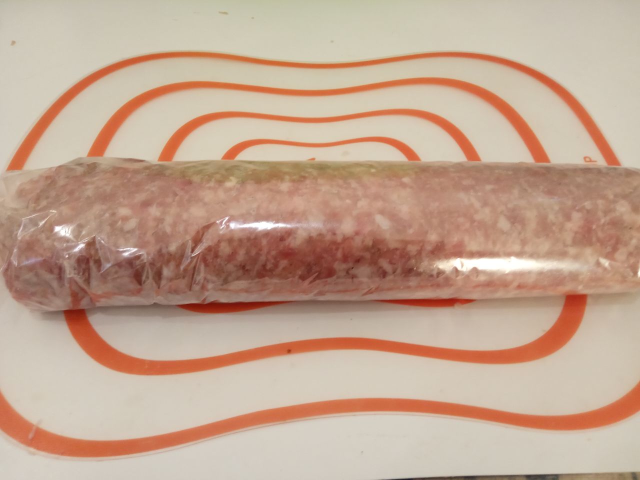 Мясной рулет с сыром в кляре, жареный на сковороде: Затем с помощью пленки сворачиваем котлетную массу рулетом.