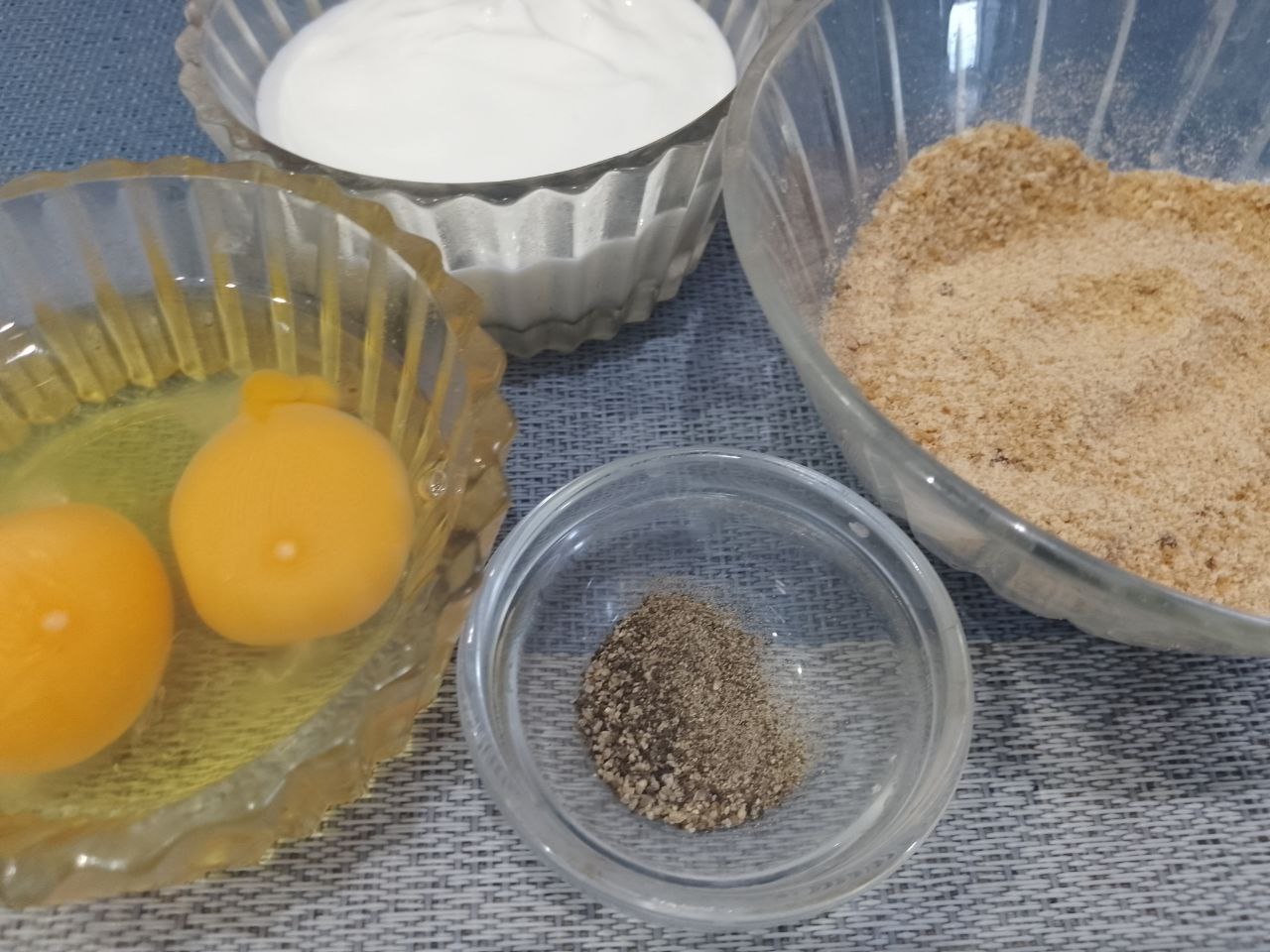 Котлеты из куриного мяса в яичном кляре и панировочных сухарях: В большой миске соединяем фарш, яйца, сметану, панировочные сухари, соль и перец.