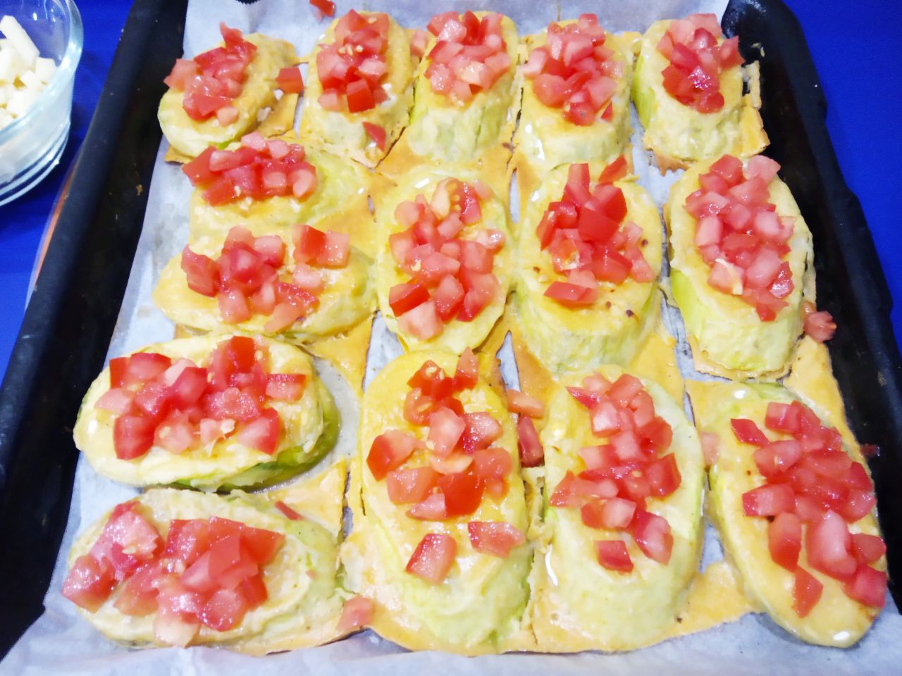 Запеченные кабачки в кляре, с сыром и помидорами: Достаем кабачки из духовки, выкладываем ряд измельченных помидор.
