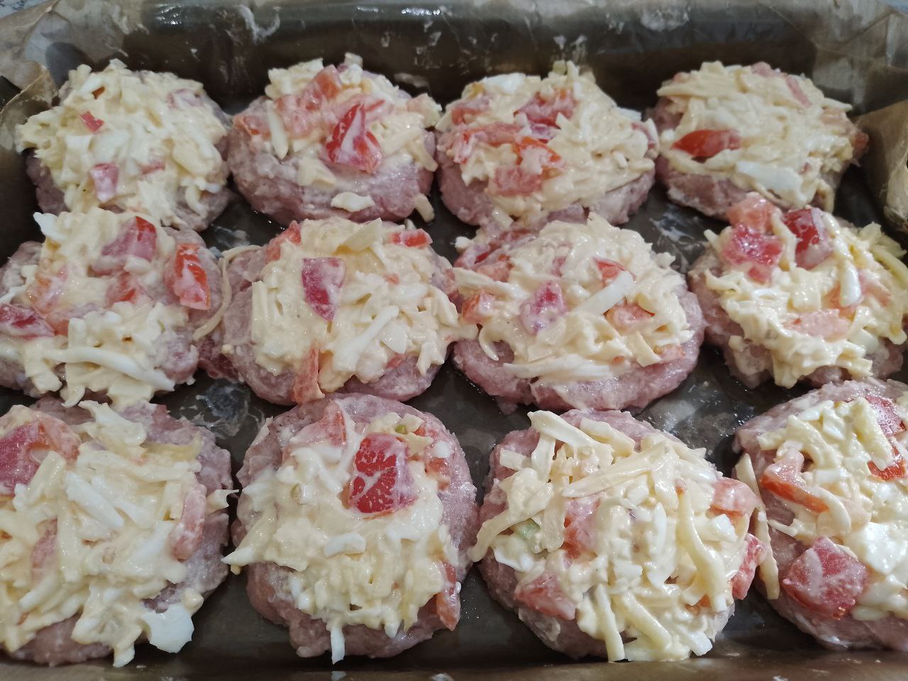 Мясные котлеты с начинкой, запеченные в духовке: Выкладываем начинку на котлеты, разравниваем.