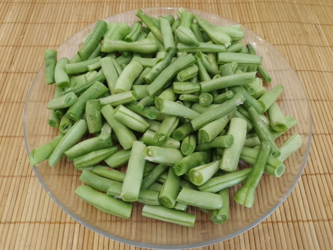 Тушеная спаржевая фасоль с овощами и куриным мясом: Фасоль промываем водой, отрезаем кончики с двух сторон. Разрезаем фасоль на кусочки длиной 3-4 см. Затем