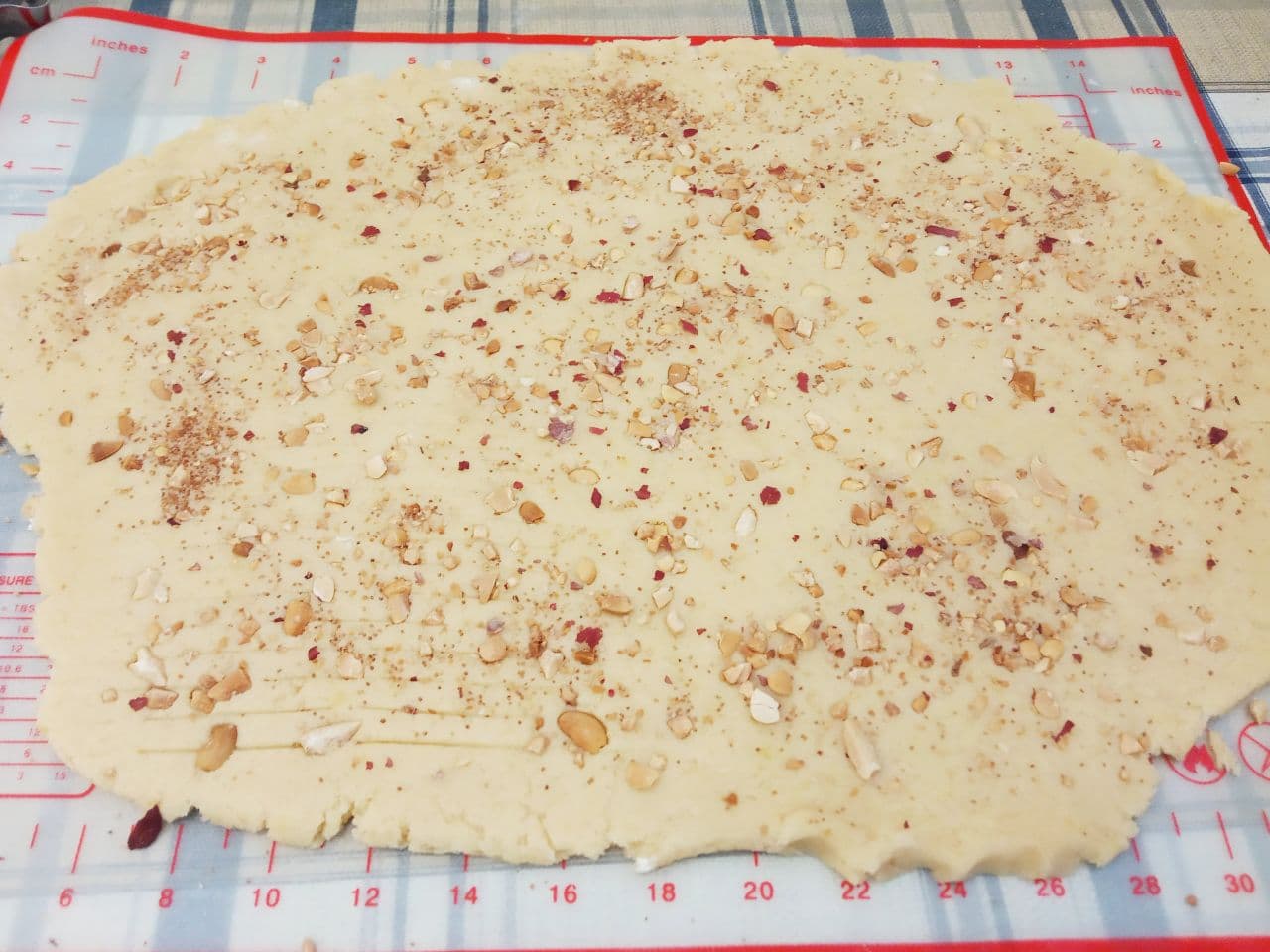 Рассыпчатое песочное домашнее печенье с крахмалом, вкусно и просто: Лист теста посыпаем измельченными орехами и по желанию валиком продавливаем узоры.