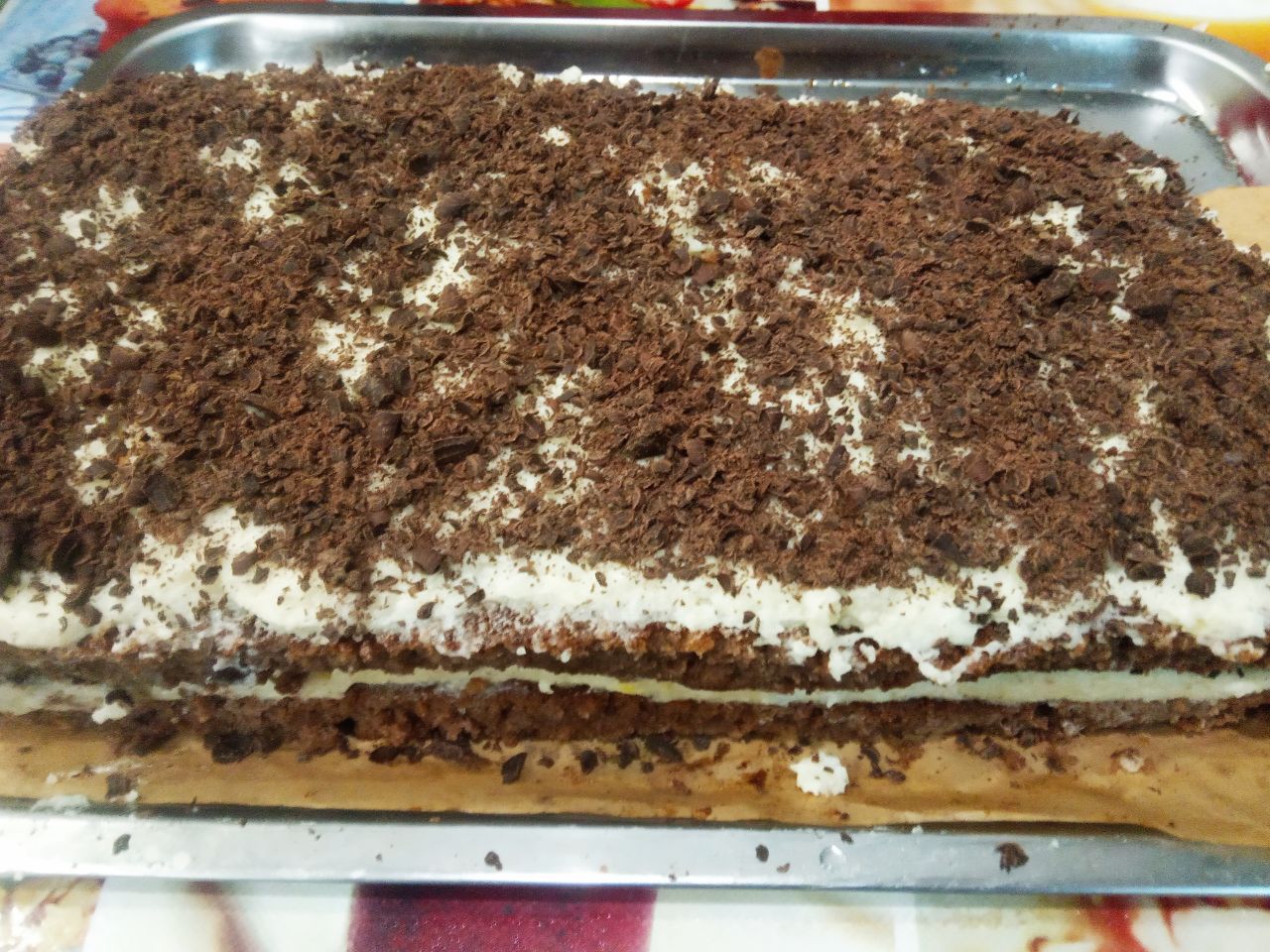 Шоколадные пирожные с кремом из манной крупы и сливочного масла: Накрываем второй частью бисквита, смазываем оставшимся кремом и посыпаем оставшимся тертым шоколадом.