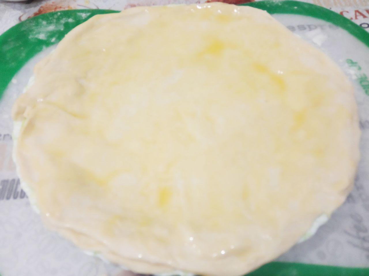Пирожки из слоёного теста с мясной начинкой: Круг теста смазываем сливочным маслом и посыпаем крахмалом.