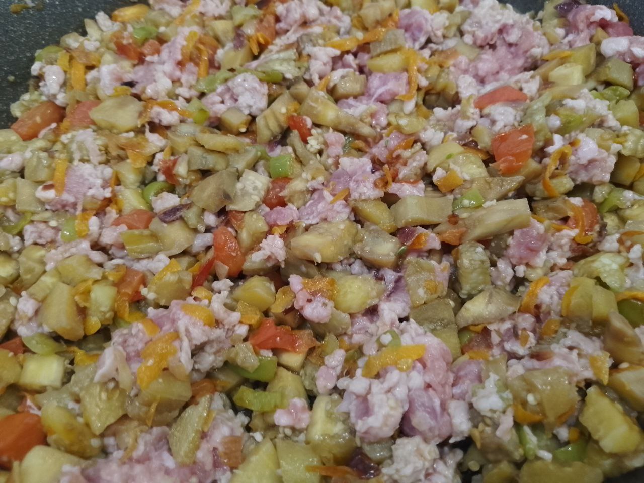 Запеченные в духовке, баклажаны с овощами, фаршем и сыром: Добавляем к овощам измельченные баклажаны и фарш, перемешиваем и обжариваем около 10 минут.