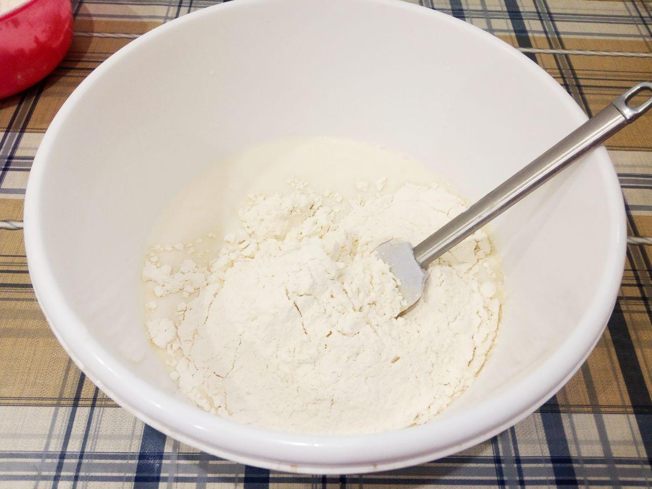 Жареные пончики без яиц с начинкой и с кунжутом: Муку просеиваем и добавляем в смесь, добавляем соль и замешиваем мягкое тесто.