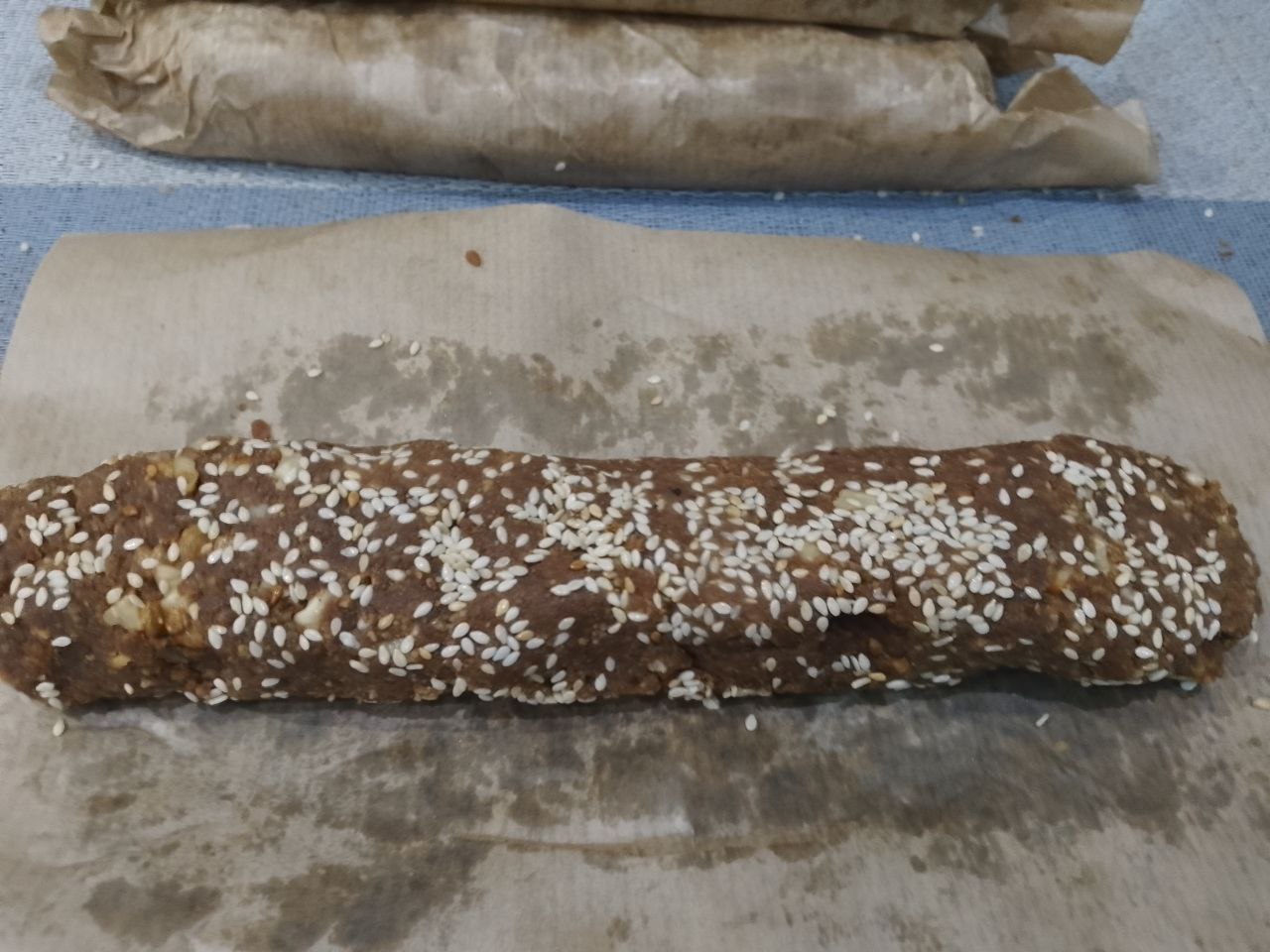 Десерт из печенья, сгущенного молока и орехов: Формируем длинную колбаску и плотно заворачиваем пергаментом.