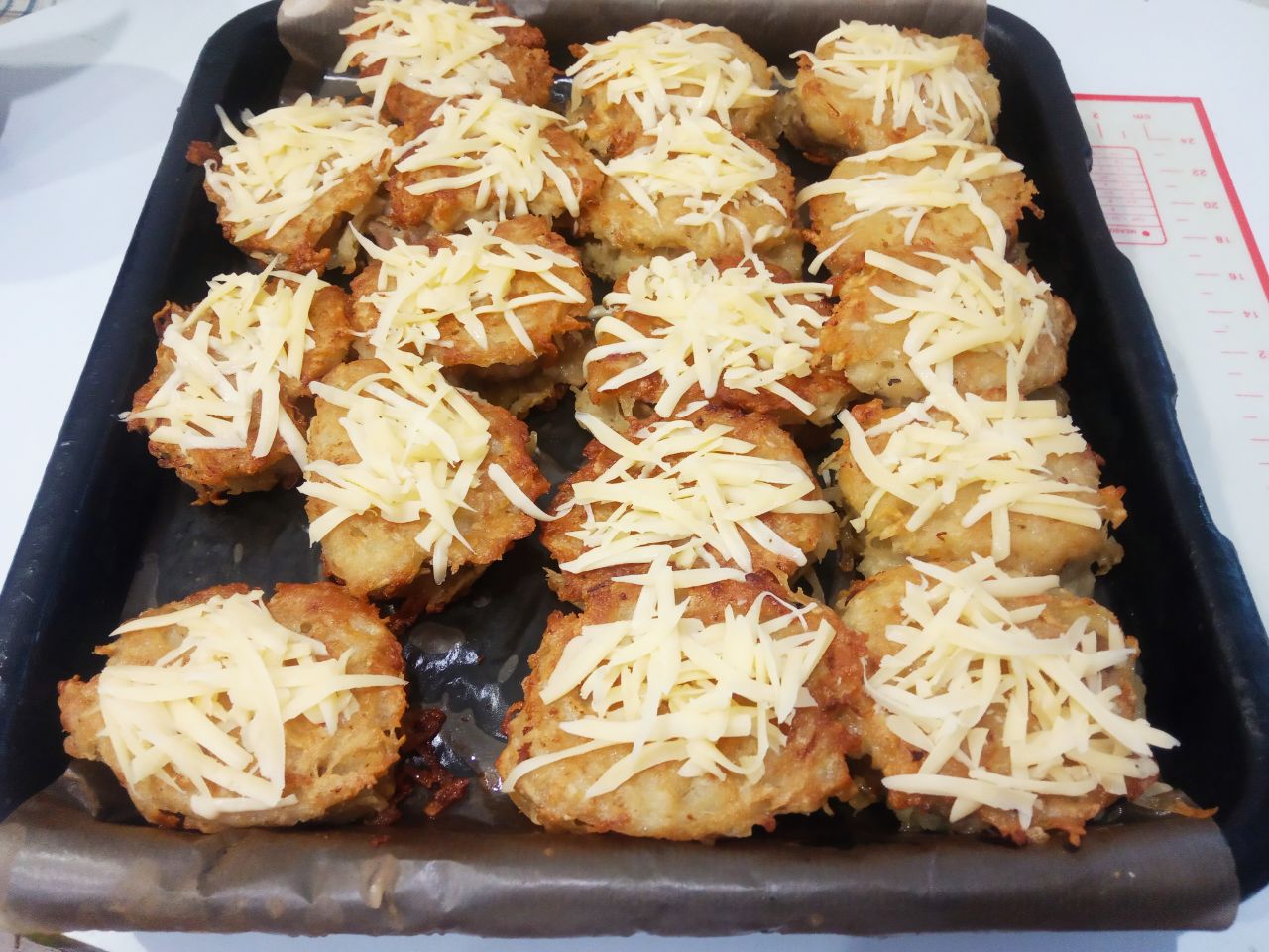 Картофельные колдуны с фаршем и сыром, вкусно и сытно: Достаем противень с духовки и посыпаем колдуны тертым сыром.