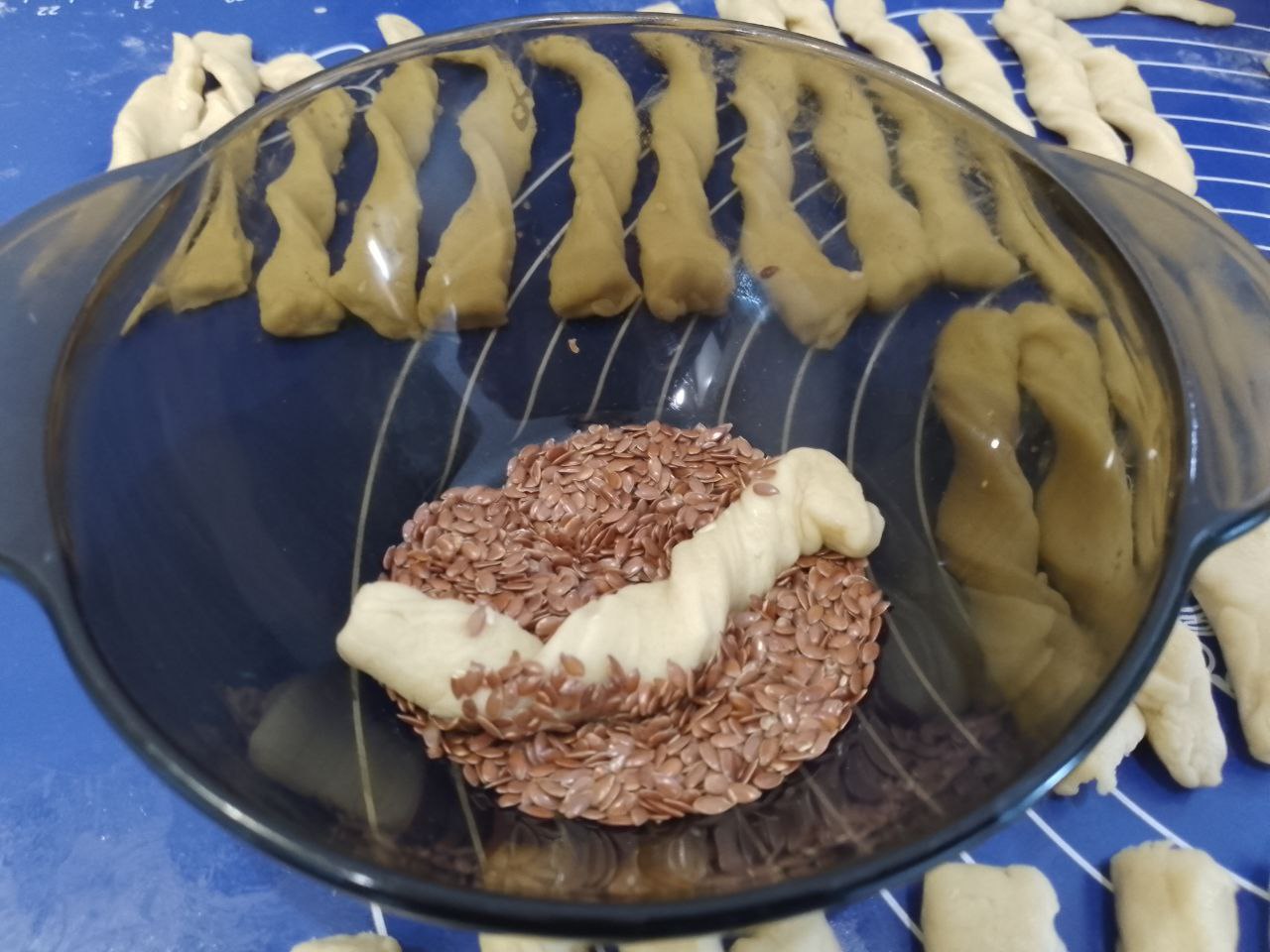 Печенье с кунжутом и семенами льна, приготовленное из теста с вареными яйцами: Скручиваем полоски спиралью и обваливаем в кунжуте и семенах льна.