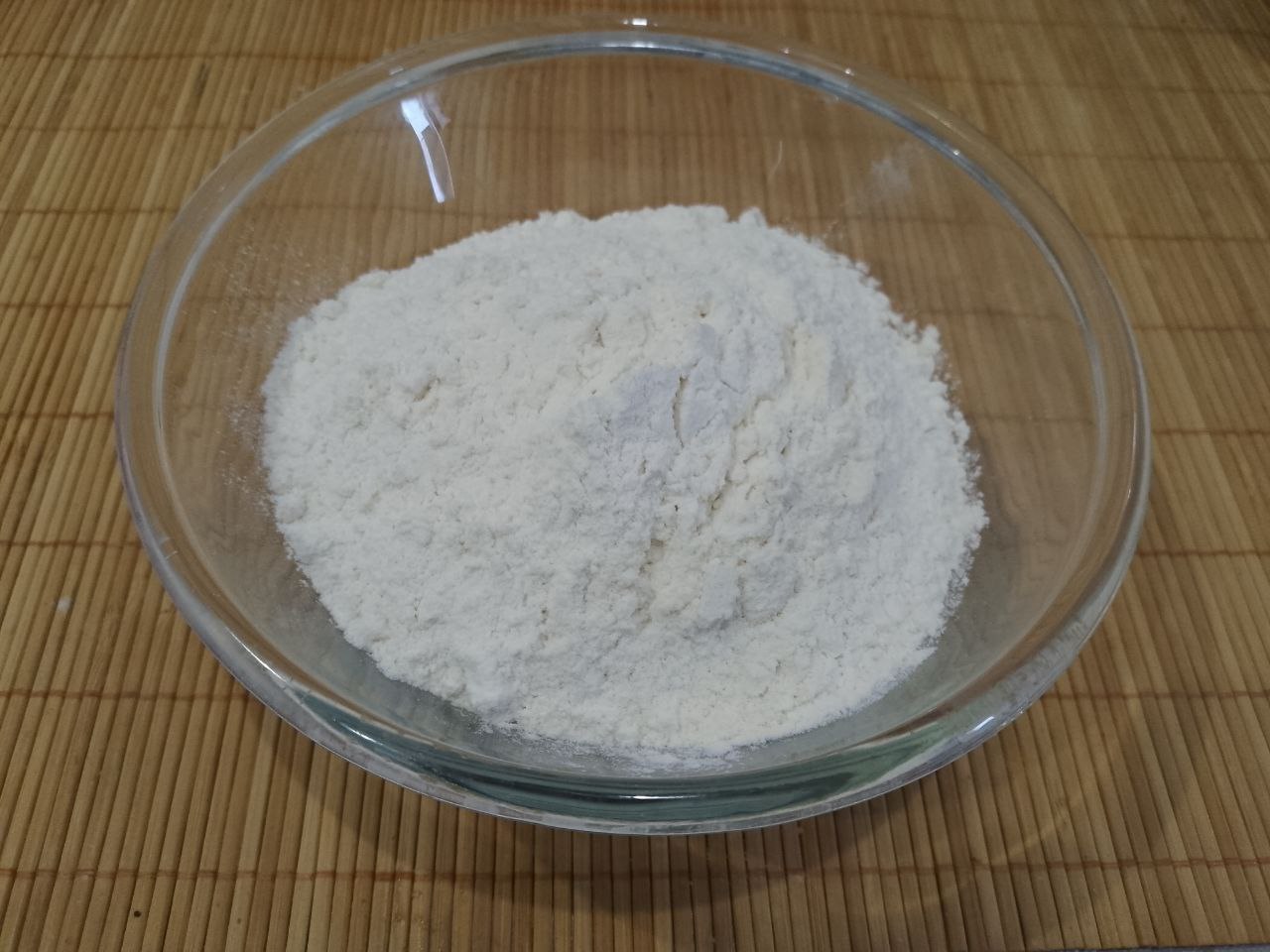 Рецепт домашнего печенья с кунжутом, мягкое и рассыпчатое: Муку просеиваем через сито и добавляем в смесь сначала половину муки, осторожно размешиваем снизу вверх.
