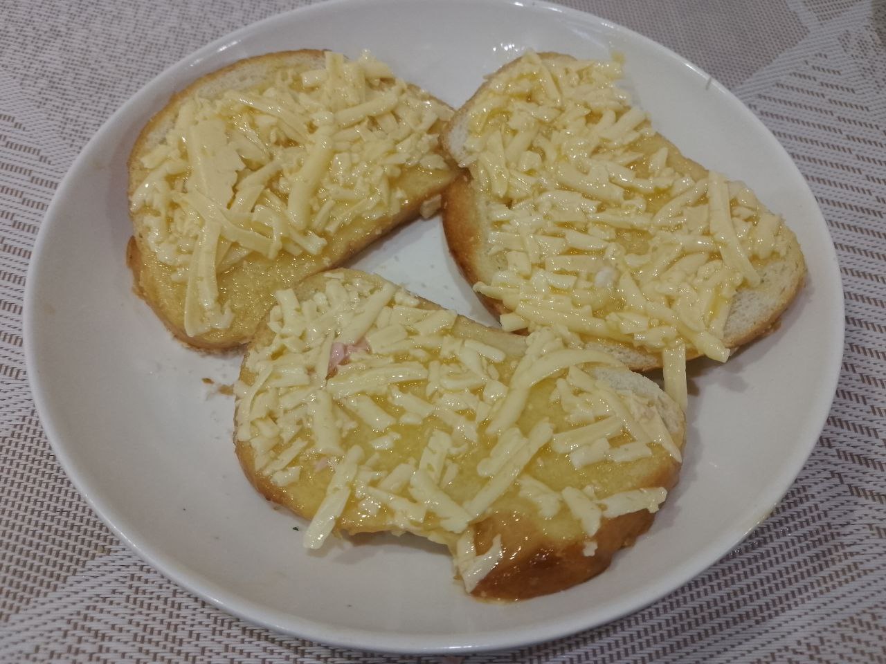 Бутерброды с яйцами и сыром, жареные на сковороде: Равномерно распределяем смесь по ломтикам батона.