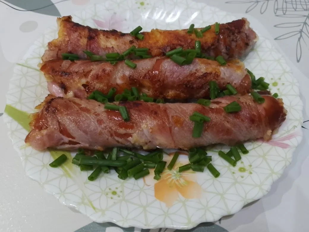 Обжаренные на сковороде, сосиски с сыром, в беконе