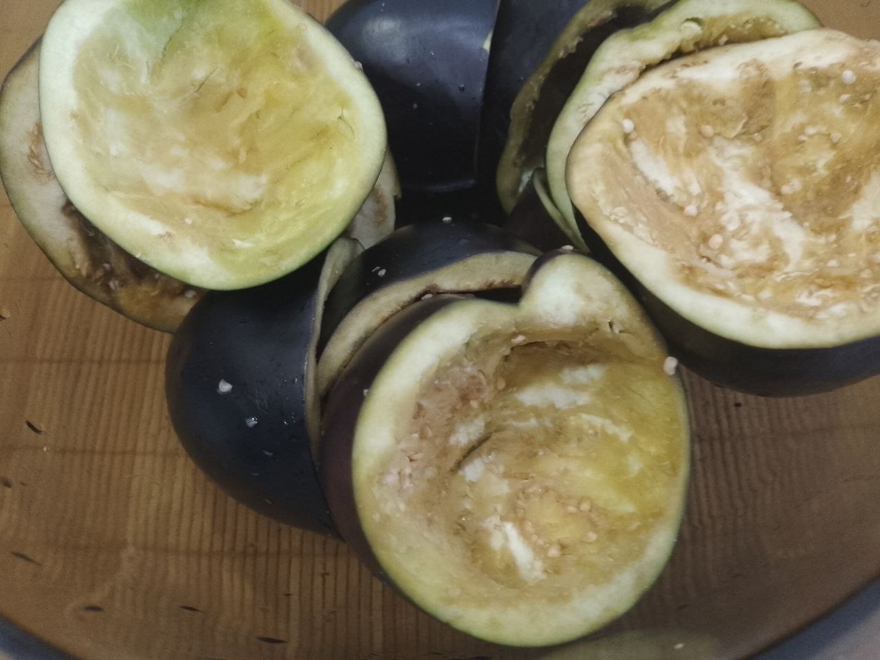 Баклажаны с начинкой из мяса и овощей, в духовке: Баклажаны промываем, отрезаем плодоножки и разрезаем на две части. Чайной ложкой удаляем середину у