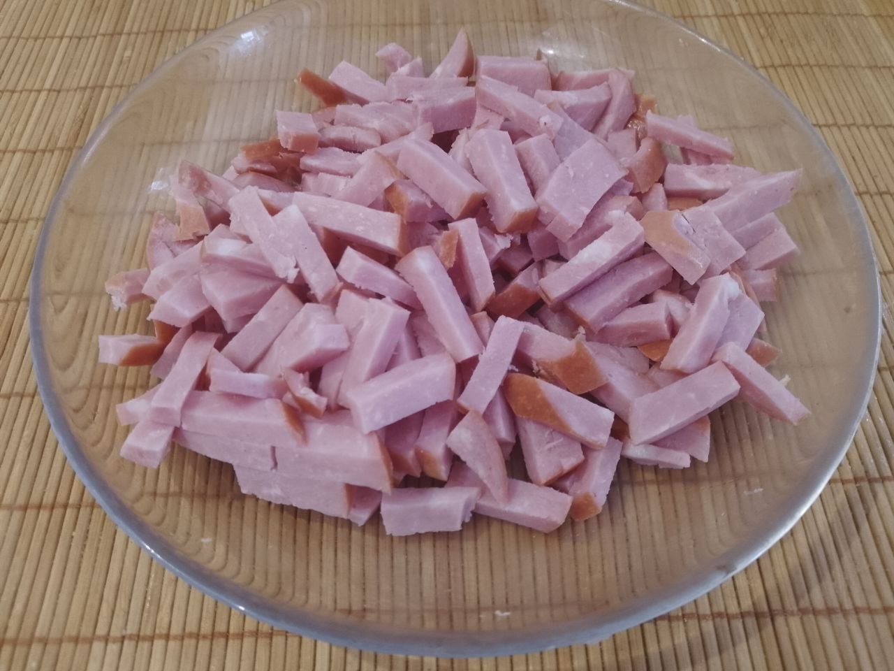Сытный, вкусный и аппетитный салат из яичных блинов, ветчины и других ингредиентов: Ветчину нарезаем соломкой или отварное мясо измельчаем.
